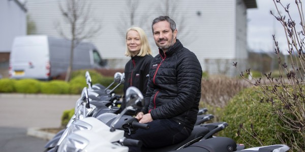Mark and Lizzi Smith sat on mopeds for Community Resource and Wheels to Work Silverstone