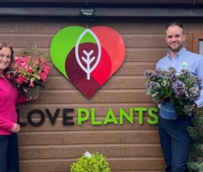 Beth Heath from Shropshire Festivals and Ed Glover from Salop Leisure holding plants in front of Love Plants sign