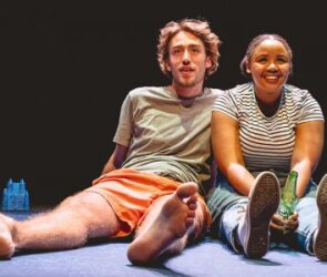 A man and a woman sat on a stage